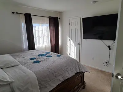 a bedroom with a bed and a flat screen tv at Ram comfort in Denver