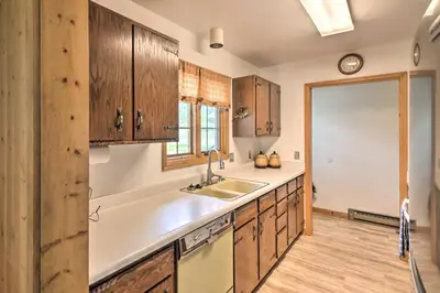 a kitchen with wooden cabinets and a sink at Rocky Mountain Breezes Cabin Grill and Deck! in Estes Park