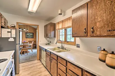 a kitchen with wooden cabinets and a sink at Rocky Mountain Breezes Cabin Grill and Deck! in Estes Park