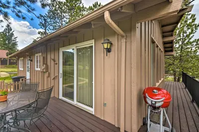 a house with a deck with a grill and a patio at Rocky Mountain Breezes Cabin Grill and Deck! in Estes Park