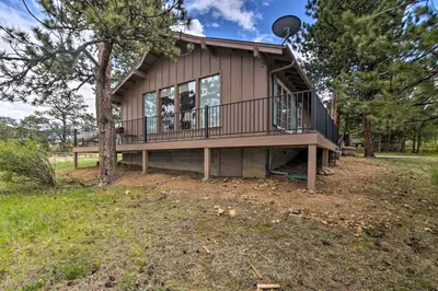 a house on a hill with a balcony at Rocky Mountain Breezes Cabin Grill and Deck! in Estes Park