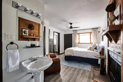 a bathroom with a sink and a bed in a room at Misty Mountain Lodge in Estes Park