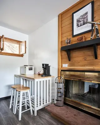 a living room with a fireplace and a table at Misty Mountain Lodge in Estes Park