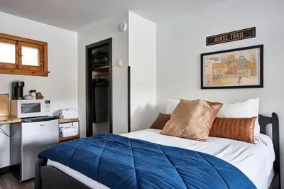 a bedroom with a bed with a blue comforter at Misty Mountain Lodge in Estes Park