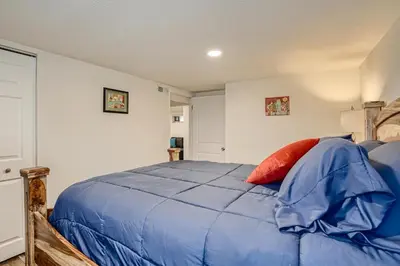 a bedroom with a blue bed with a red pillow at Sloans Lake Getaway - Basement Apartment Near Broncos and Downtown Denver in Lakewood