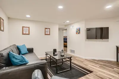 a living room with a couch and a flat screen tv at Sloans Lake Getaway - Basement Apartment Near Broncos and Downtown Denver in Lakewood