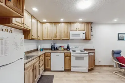 a kitchen with wooden cabinets and white appliances at Hi Country 816 in Winter Park