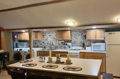 a kitchen with a table and a kitchen with appliances at Thorpe On The Water. Creekside Nederland Cabin. in Nederland