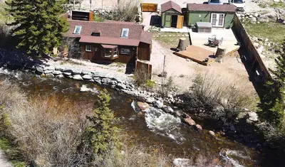 an aerial view of a house next to a river at Thorpe On The Water. Creekside Nederland Cabin. in Nederland