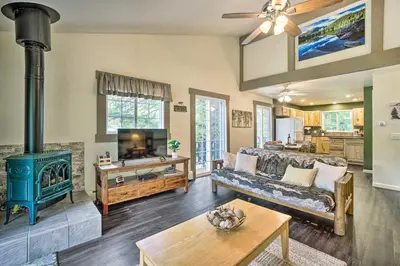 a living room with a couch and a stove at Cozy Condo on Fall River - 1 Mile to RMNP Gate! in Estes Park