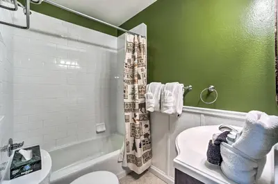 a bathroom with a toilet and a green wall at Cozy Condo on Fall River - 1 Mile to RMNP Gate! in Estes Park