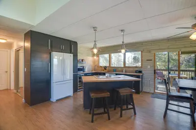 a kitchen with a white refrigerator and a counter at Cozy Red Feather Lakes Retreat with Deck and Yard in Red Feather Lakes