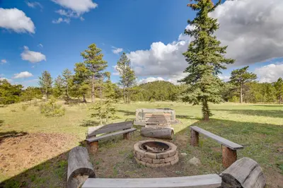 a picnic table and a fire pit in a field at Cozy Red Feather Lakes Retreat with Deck and Yard in Red Feather Lakes