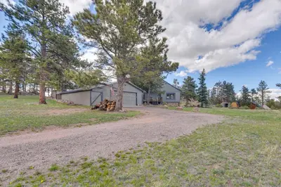 an empty road in front of a house at Cozy Red Feather Lakes Retreat with Deck and Yard in Red Feather Lakes