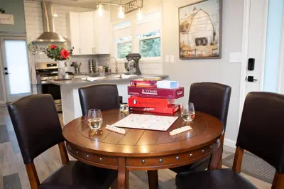 a table with wine glasses and books on it in a kitchen at Cozy Bungalow Hot Tub & Fire Pit, Walk Downtown in Loveland