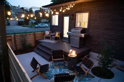 a patio with chairs and a grill on a house at Cozy Bungalow Hot Tub & Fire Pit, Walk Downtown in Loveland