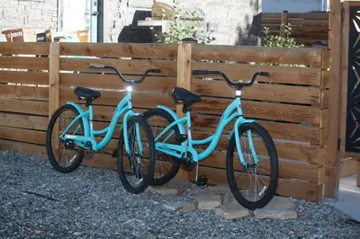 two bikes are parked next to a fence at Cozy Bungalow Hot Tub & Fire Pit, Walk Downtown in Loveland