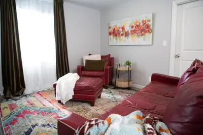 a living room with a red couch and a chair at Cozy Bungalow Hot Tub & Fire Pit, Walk Downtown in Loveland