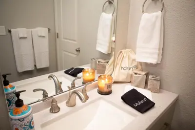 a bathroom with a sink with candles and a mirror at Cozy Bungalow Hot Tub & Fire Pit, Walk Downtown in Loveland