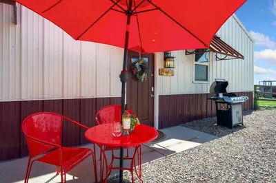 a red table with two chairs and a red umbrella at Llama-Stay at Spooky Tooth Ranch - Mtn Views! in Loveland