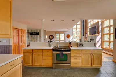 a kitchen with wooden cabinets and a stove top oven at Spacious Townhome Near Main St and Lake Dillon! in Frisco