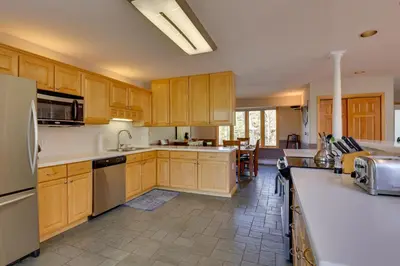 a kitchen with wooden cabinets and stainless steel appliances at Spacious Townhome Near Main St and Lake Dillon! in Frisco