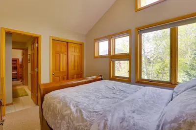 a bedroom with a bed and two windows at Spacious Townhome Near Main St and Lake Dillon! in Frisco