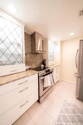 a kitchen with white cabinets and a stainless steel refrigerator at 1777 Larimer St #1911 in Denver