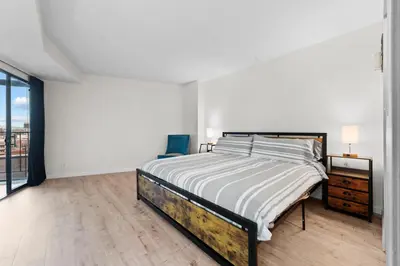 a white bedroom with a bed and a large window at 1777 Larimer St #903 in Denver
