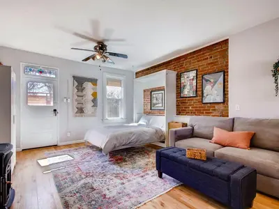 a living room with a couch and a brick wall at 3329 W 31st in Denver