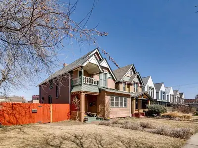 a row of houses with a orange fence at 3329 W 31st in Denver