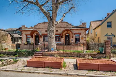 a brick house with a tree in front of it at 1374 S Pennsylvania St in Denver