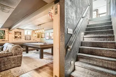 a stairway leading to a living room with a pool table at 5235 E Atlantic Pl in Denver