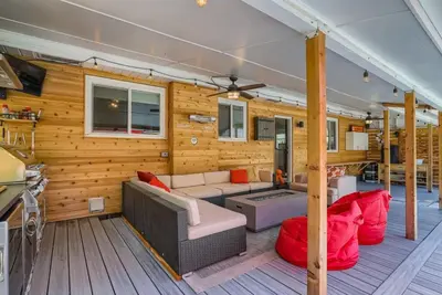a living room with wooden walls and a couch and red pillows at 5235 E Atlantic Pl in Denver