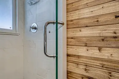 a bathroom with a shower with a wooden wall at 5235 E Atlantic Pl in Denver