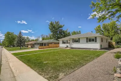 a white house with a yard at 5235 E Atlantic Pl in Denver
