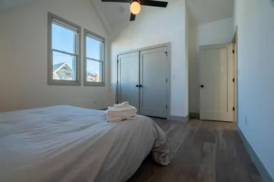 a white bedroom with a bed and two windows at 139 West Ellsworth in Denver