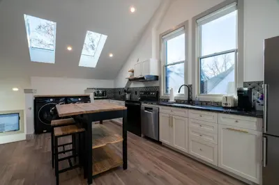 a kitchen with white cabinets and black counter tops at 139 West Ellsworth in Denver