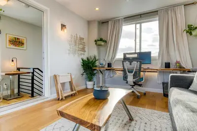 a living room with a desk and a computer at Walk to Empower Field Townhome with Hot Tub! in Denver