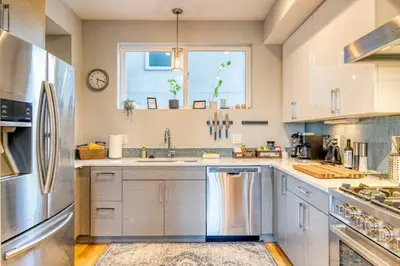 a kitchen with stainless steel appliances and a window at Walk to Empower Field Townhome with Hot Tub! in Denver
