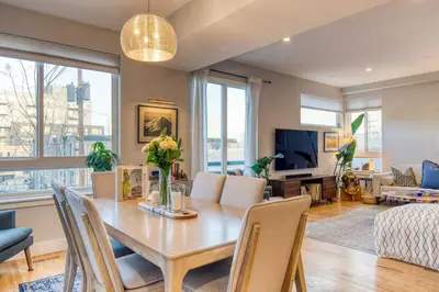 a dining room and living room with a table and chairs at Walk to Empower Field Townhome with Hot Tub! in Denver