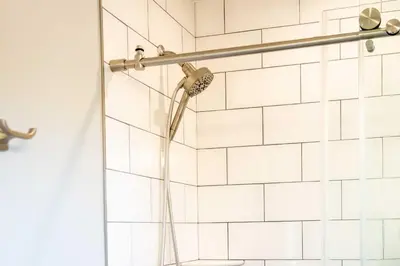 a shower with a shower head in a bathroom at Golden Cottage Near Red Rocks and School of Mines! in Golden