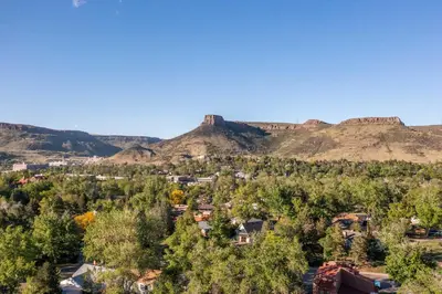 an aerial view of a town with mountains in the background at Golden Cottage Near Red Rocks and School of Mines! in Golden