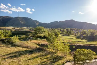 a view of a golf course with mountains in the background at Golden Cottage Near Red Rocks and School of Mines! in Golden