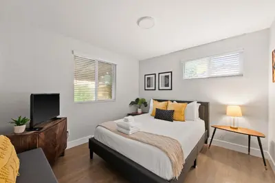 a bedroom with a large bed and a television at Modern Retreat With Patio & Sunset Views - Gray St in Arvada