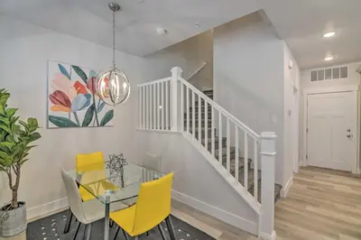 a dining room with a glass table and yellow chairs at Gorgeous Greeley Getaway - Close to Parks! in Greeley