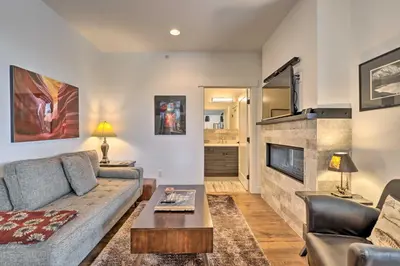 a living room with a couch and a fireplace at Grand Lake Condo with Balcony and Mountain Views in Grand Lake
