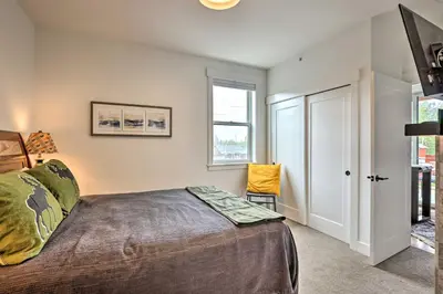 a bedroom with a bed and a window at Grand Lake Condo with Balcony and Mountain Views in Grand Lake