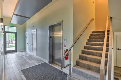 a hallway with stairs and a stair case at Grand Lake Condo with Balcony and Mountain Views in Grand Lake