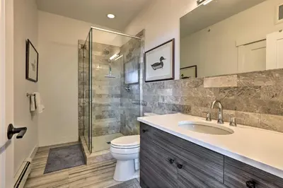 a bathroom with a shower and a toilet and a sink at Grand Lake Condo with Balcony and Mountain Views in Grand Lake